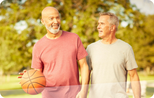 Photo of two men wearing athletic clothing playing a friendly game of basketball. 