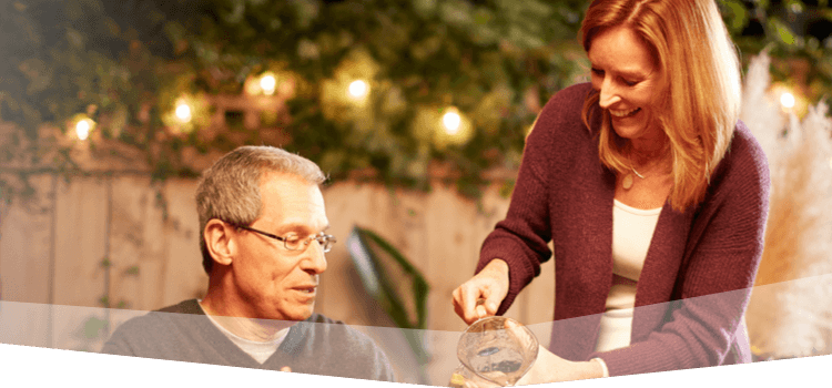 Banner photo at the top of the page showing a man hosting a backyard barbecue and sitting down to dinner with friends and family.  