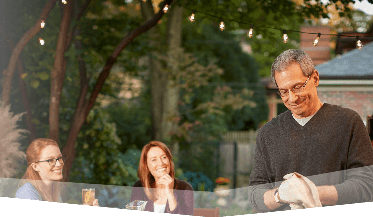 Banner photo at the top of the page showing a man hosting a backyard barbecue with friends and family.  