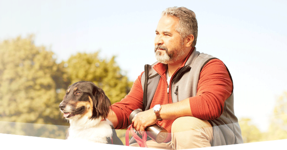 Banner photo at the top of the page showing a man crouching next to his dog, taking in the scenery of a beautiful day at the park.  