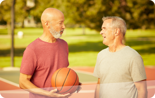 Photograph of two men talking engaged in friendly conversation with each other on a basketball court.